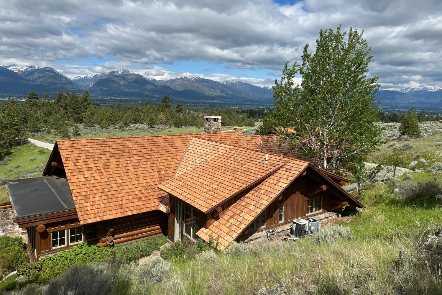Rustic cabin with mountain views and greenery.