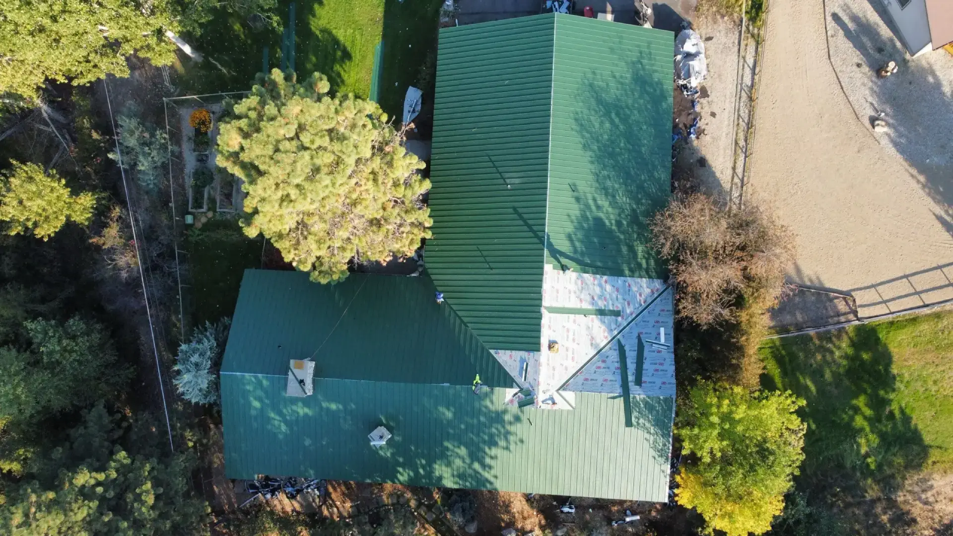 Aerial view of green-roofed house and yard